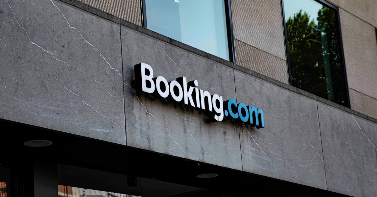 Close-up of a 3D Booking.com logo on a neutral concrete building facade.