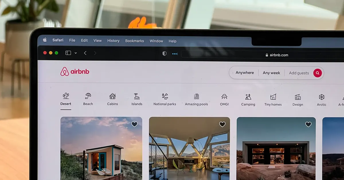 Airbnb website displayed on a laptop screen, showing accommodation listings and category-based search options.